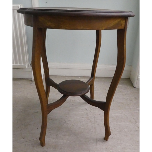 60 - A mid 20thC mahogany occasional table, having a serpentine outlined top, raised on cabriole legs, un... 