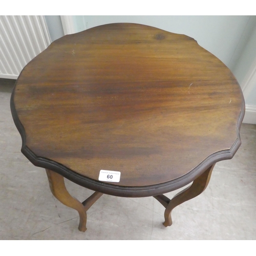 60 - A mid 20thC mahogany occasional table, having a serpentine outlined top, raised on cabriole legs, un... 
