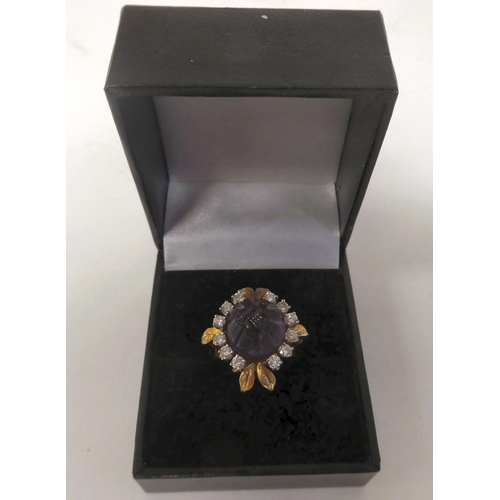 65 - An 18ct gold, claw set, amethyst and diamond cluster ring