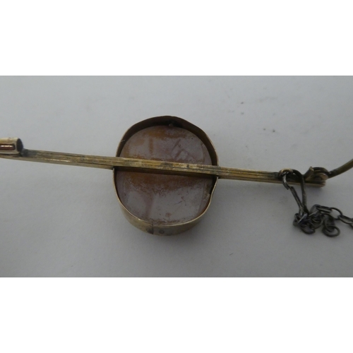 76 - A yellow metal bar brooch, set with an oval cameo, a study of a woman in a woodland