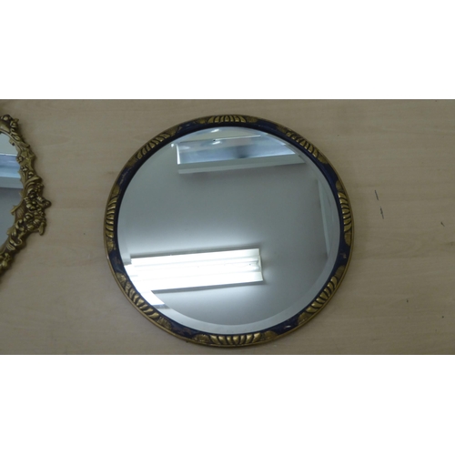 85 - Four dissimilar mirrors: to include one with a bevelled edge, set in a carved and stained hardwood f... 