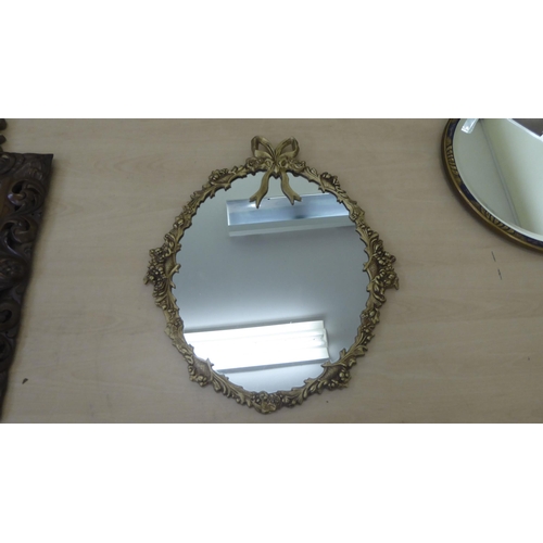 85 - Four dissimilar mirrors: to include one with a bevelled edge, set in a carved and stained hardwood f... 