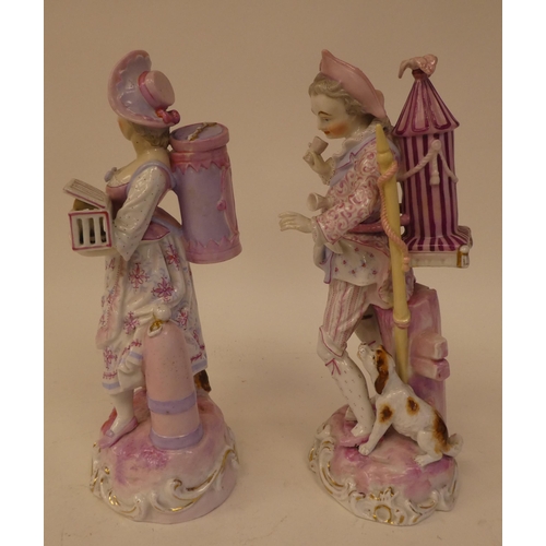 132 - A pair of 20thC Continental porcelain figures, one an itinerant entertainer wearing a tricorn hat, t... 