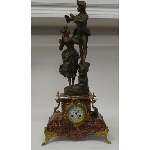 133 - A late 19thC French mantel clock, the mottled iron red marble case surmounted by a painted spelter g... 