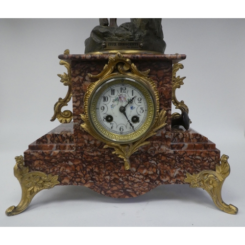 133 - A late 19thC French mantel clock, the mottled iron red marble case surmounted by a painted spelter g... 