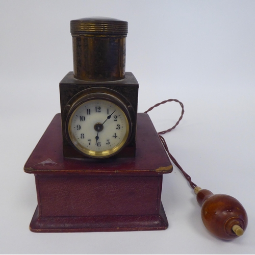 25 - A vintage lacquered brass and maroon hide covered, battery operated pigeon racer's timepiece, compri... 