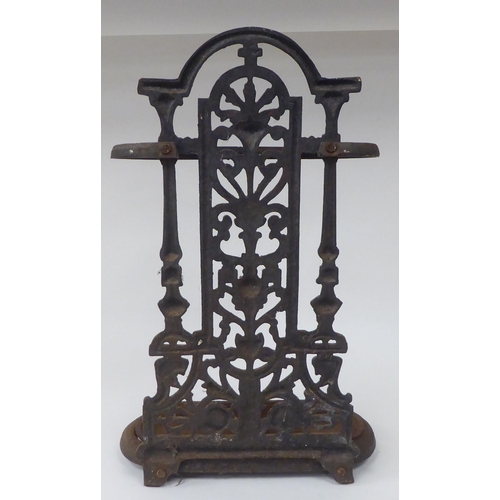 27 - A late Victorian cast iron stickstand, the pierced upstand decorated with vase and floral ornament, ... 