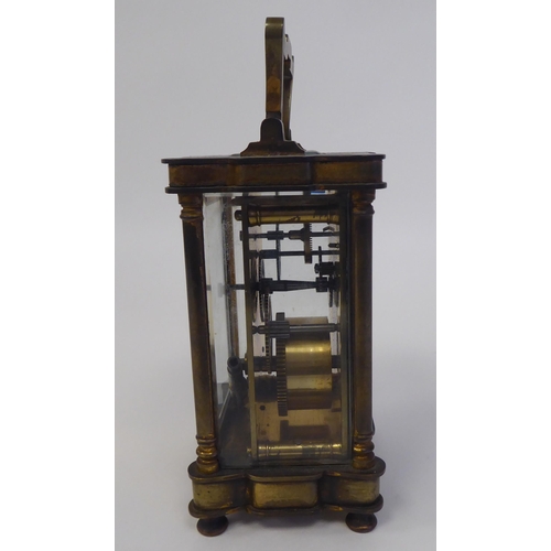 51 - A 1920s lacquered brass cased carriage timepiece with bevelled glass panels and a folding top handle... 