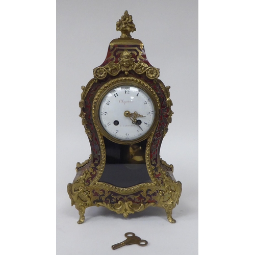 81 - A 19thC French red boulle cased mantel clock of waisted form with gilt metal mounts; the bell strike... 