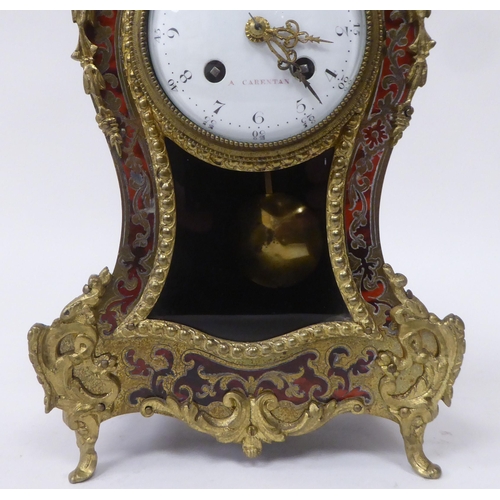 81 - A 19thC French red boulle cased mantel clock of waisted form with gilt metal mounts; the bell strike... 