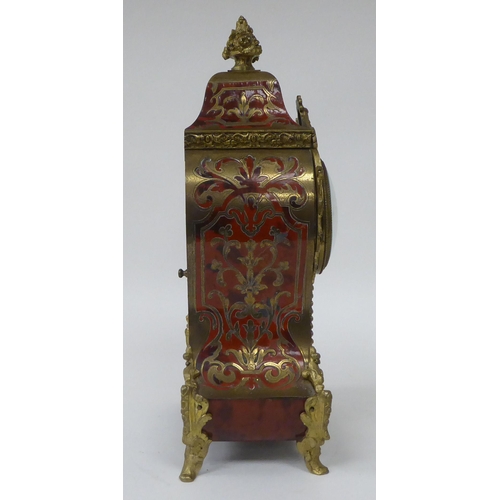 81 - A 19thC French red boulle cased mantel clock of waisted form with gilt metal mounts; the bell strike... 