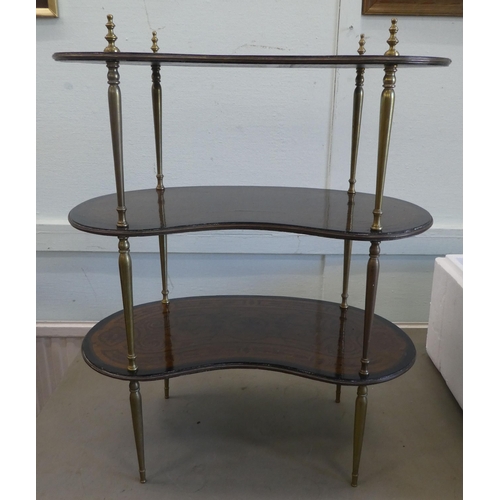 82 - An early 20thC overpainted mahogany kidney shaped three tier whatnot, elevated on tapered, brass sup... 