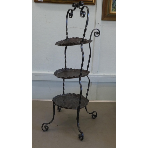 84 - An Art Nouveau inspired wrought iron framed and spot-hammered three tier brass tray cakestand  ... 