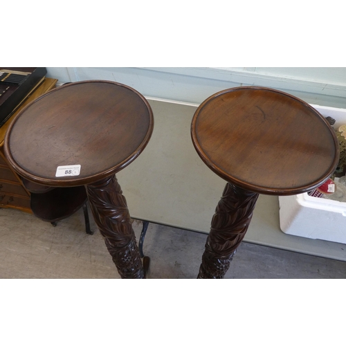 88 - A pair of modern carved mahogany torcheres, raised on tripod bases  57