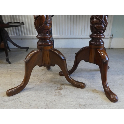 88 - A pair of modern carved mahogany torcheres, raised on tripod bases  57