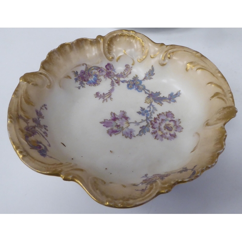 90 - Limoges porcelain tableware, decorated with pastel coloured flowers and gilt banding 