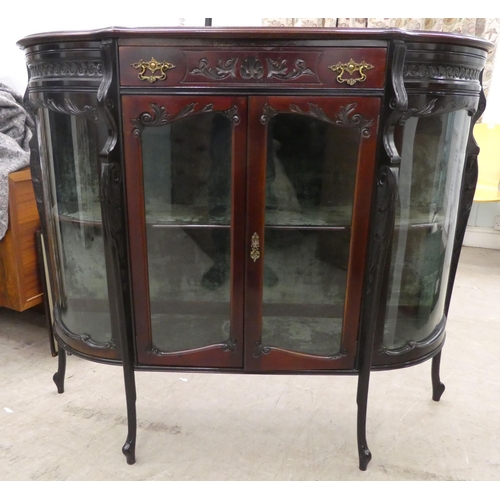 98 - An Edwardian mahogany credenza with a breakfront, bowed sides and glazed panels, enclosing two shelv... 