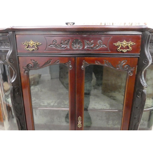 98 - An Edwardian mahogany credenza with a breakfront, bowed sides and glazed panels, enclosing two shelv... 