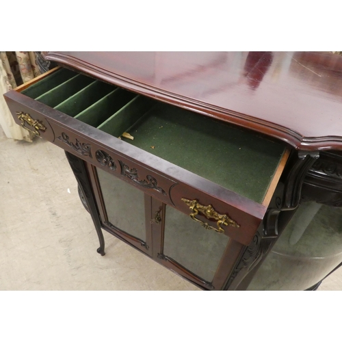 98 - An Edwardian mahogany credenza with a breakfront, bowed sides and glazed panels, enclosing two shelv... 