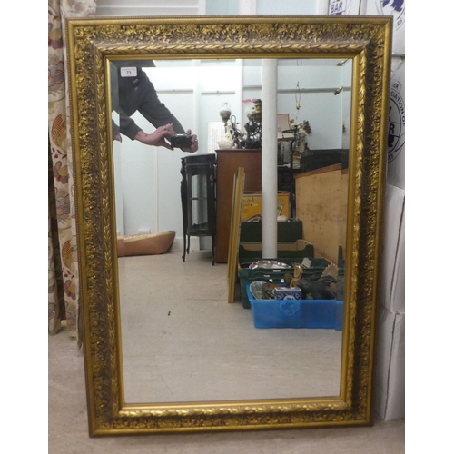 73 - A modern mirror, the bevelled plate set in a textured effect and moulded gilt frame  32