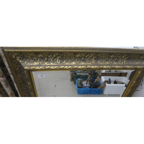 73 - A modern mirror, the bevelled plate set in a textured effect and moulded gilt frame  32