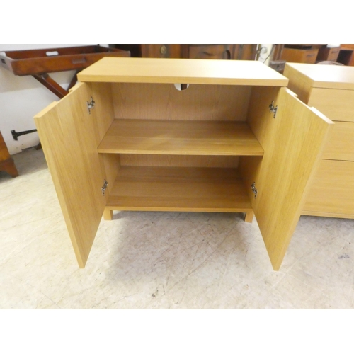 11 - Modern light oak finished furniture, viz. a three drawer dressing chest, on a plinth  29