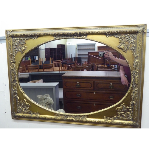 28 - A 20thC mirror, the oval plate set in an antique inspired, moulded gilt frame  30
