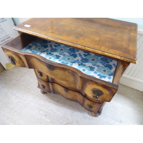 103 - An early 20thC Continental walnut moulded block front chest, comprising four graduated long drawers ... 