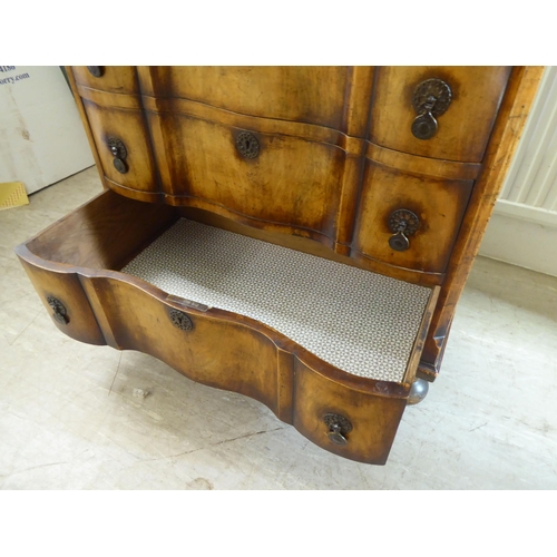 103 - An early 20thC Continental walnut moulded block front chest, comprising four graduated long drawers ... 