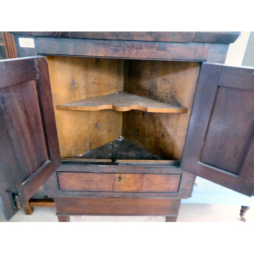 115 - An early 19thC Georgian mahogany hanging corner cupboard with two fielded panelled doors, over a bas... 