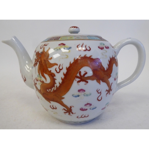 120 - An early 20thC Chinese porcelain teapot of globular form with a swept spout, loop handle, cover and ... 