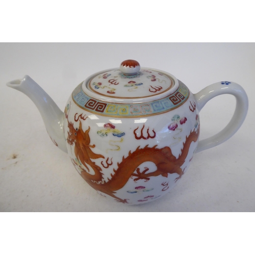 120 - An early 20thC Chinese porcelain teapot of globular form with a swept spout, loop handle, cover and ... 