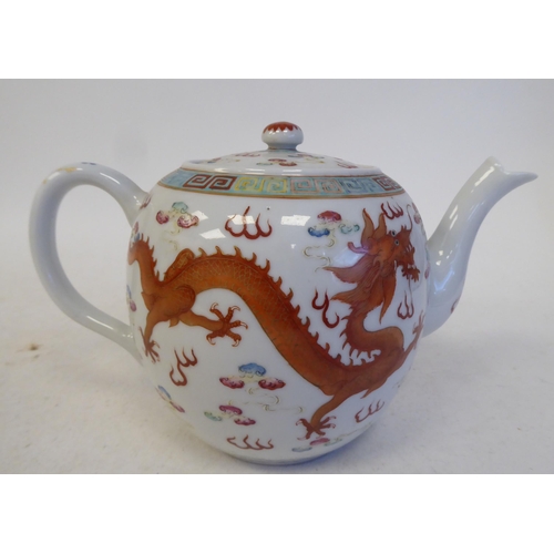 120 - An early 20thC Chinese porcelain teapot of globular form with a swept spout, loop handle, cover and ... 