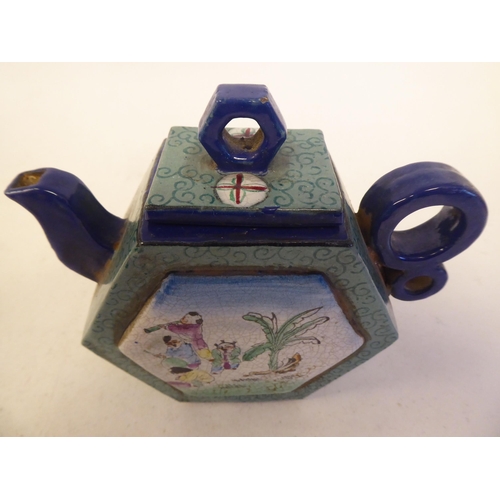 125 - A Chinese Yixing porcelain teapot of hexagonal form with a stubby double ring handle, cover and knop... 