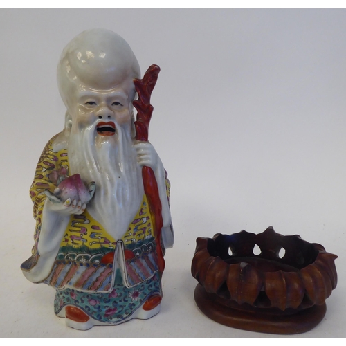 128 - An early 20thC Chinese porcelain figure, a robed, standing scholar, decorated in famille rose and hi... 