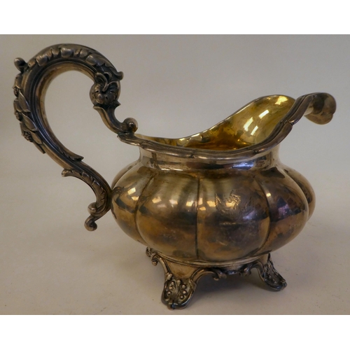 131 - A George IV silver melon shape cream jug with a flared rim on S-scrolled handle, on a shell cast foo... 