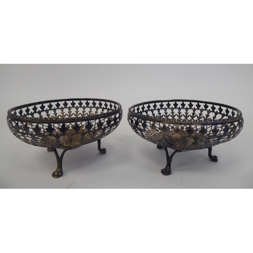 178 - A pair of silver sweet baskets with decoratively pierced, shallow sides, elevated on three paw feet&... 