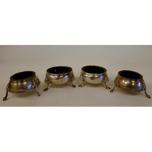 55 - A pair of George III silver shallow, bulbous salt cellars with blue glass liners, on hoof feet ... 