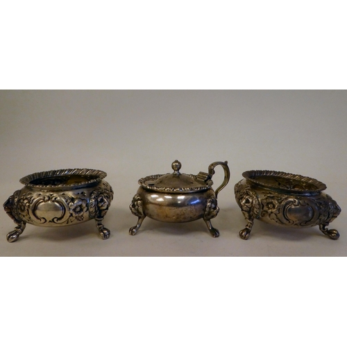 64 - A pair of early Victorian silver shallow, bulbous salt cellars with embossed floral decoration, elev... 