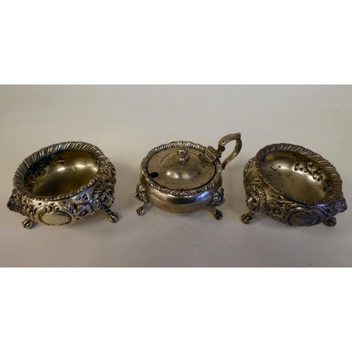 64 - A pair of early Victorian silver shallow, bulbous salt cellars with embossed floral decoration, elev... 