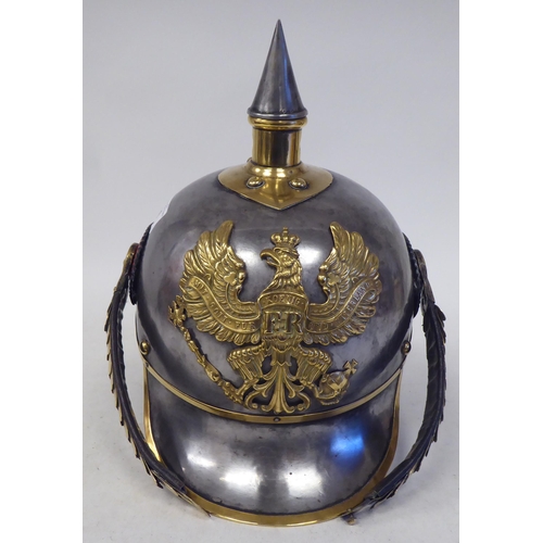 66 - A German Great War spiked, polished steel and brass cavalry helmet with a hide liner and chinstrap(P... 