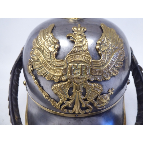 66 - A German Great War spiked, polished steel and brass cavalry helmet with a hide liner and chinstrap(P... 