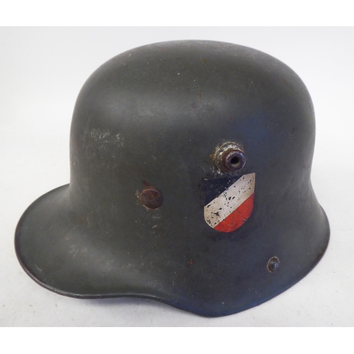 79 - A German Great War military, steel helmet used by the SS in World War II with a hide liner and two d... 