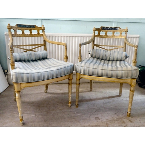 83 - A pair of early 20thC Regency inspired, cream painted and gilded elbow chairs with low, curved backs... 