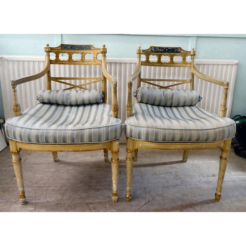 83 - A pair of early 20thC Regency inspired, cream painted and gilded elbow chairs with low, curved backs... 