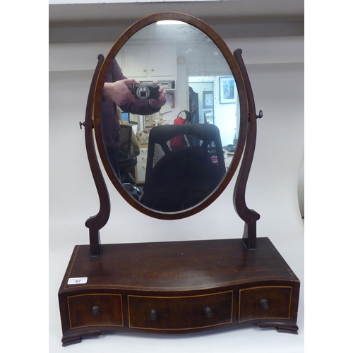 87 - An Edwardian satinwood string inlaid mahogany toilet mirror, the oval plate pivoting on shaped horns... 