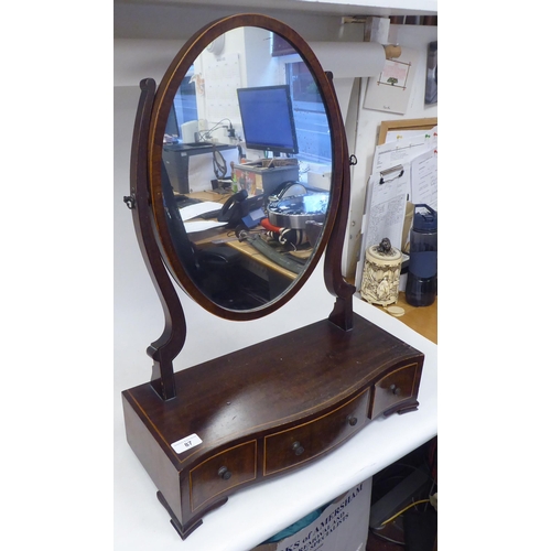 87 - An Edwardian satinwood string inlaid mahogany toilet mirror, the oval plate pivoting on shaped horns... 