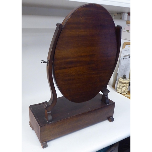 87 - An Edwardian satinwood string inlaid mahogany toilet mirror, the oval plate pivoting on shaped horns... 