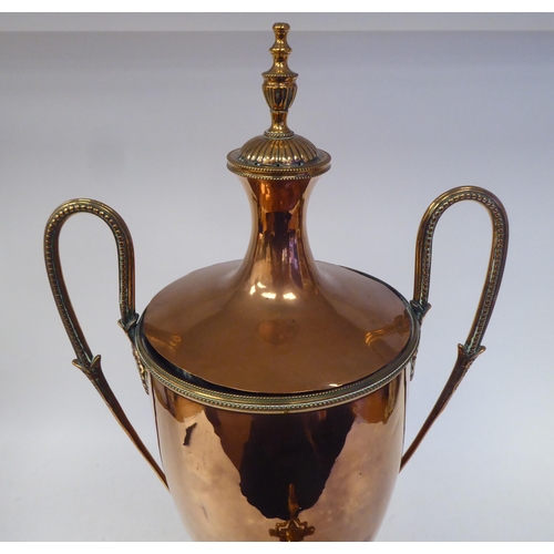 92 - A mid 19thC neo classically styled copper pedestal samovar of twin handled, ovoid form with a cover,... 