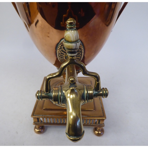 92 - A mid 19thC neo classically styled copper pedestal samovar of twin handled, ovoid form with a cover,... 